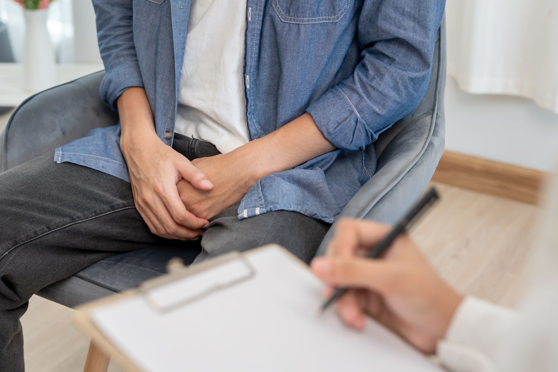 muž v ordinácii urológa má prekrížené dlane na rozkroku